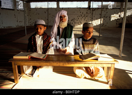 Deux enfants et un enseignant d'une école religieuse, Madrasah, au Pakistan. Banque D'Images