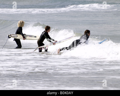 Trois jeunes surfeurs dans l'eau, Cornwall, UK Banque D'Images