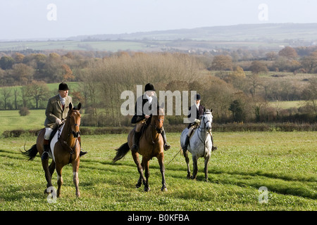 Membres de Heythrop Hunt ride à travers champ à Westcote les Cotswolds Oxfordshire Royaume-Uni Banque D'Images