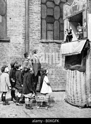 Les enfants regardant un Punch and Judy show dans une rue de Londres, 1936. Artiste : Donald McLeish Banque D'Images