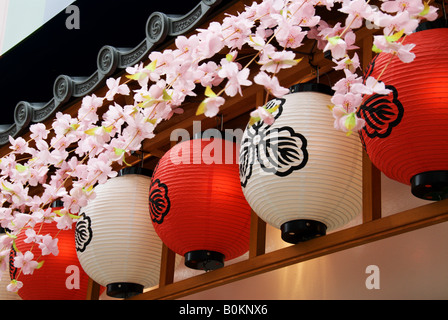 Lanternes rouge et blanc indiquant un restaurant ou un bar dans la région d'Asakusa de Tokyo sont en plastique décorées de fleurs de cerisiers. Banque D'Images