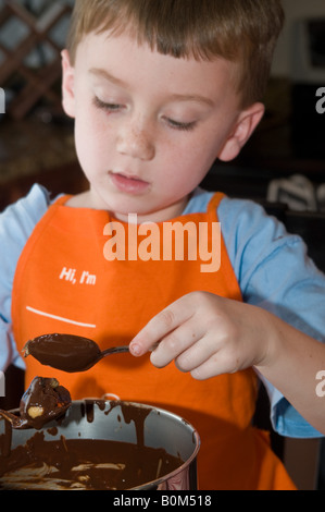 L'activité de famille d'accueil qui fait le beurre d'arachide de chocolat oeufs de Pâques traditionnel traiter. Petit-enfant grand-mère Banque D'Images