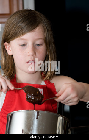 L'activité de famille d'accueil qui fait le beurre d'arachide de chocolat oeufs de Pâques traditionnel traiter. Petit-enfant grand-mère Banque D'Images