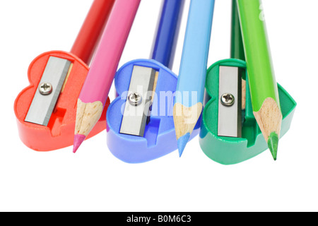 Crayons de couleur et taille-crayons organisé sur fond blanc Banque D'Images