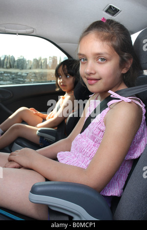 Deux soeurs de la course mixte est assis à l'arrière d'une voiture. Banque D'Images