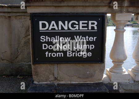 Inscription en ligne sur le pont sur la Sepentine dans Hyde Park Londres Danger l'eau peu profonde Banque D'Images