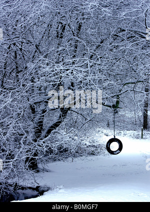 Neige scène picturale représentant un pneu en caoutchouc avec swing corde accrochée à un arbre. Le concept des pneus d'hiver Banque D'Images