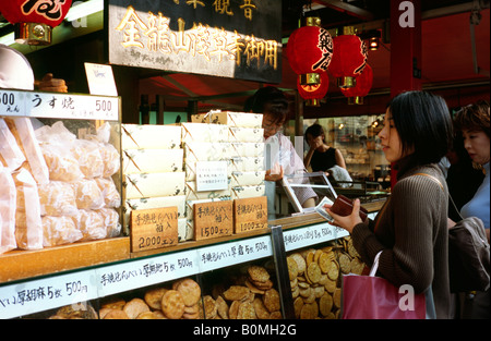 Nov 7, 2004 - femme achète des cookies sur le centre commercial Nakamise Dori dans le quartier historique d'Asakusa de Tokyo. Banque D'Images