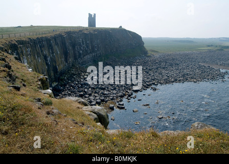 Les ruines de château de Dunstanburgh donnant sur la côte de Craster, Northumberland, Angleterre. Banque D'Images