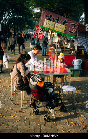 Jeune famille savourer un repas du soir en plein air à Yoyogi Park dans la capitale japonaise de Tokyo. Banque D'Images