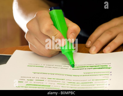 Les mains d'un élève à l'aide d'un marqueur vert sur l'université de l'école avec trois notes allumé deux bulbed les flashes Speedlite de la température et un backl Banque D'Images