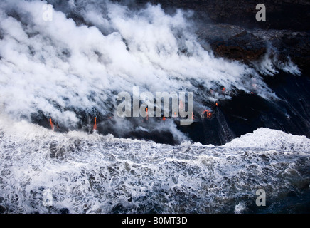 Le flux de lave côtières à partir de l'éruption du volcan Kilauea aux vagues de l'océan de magma chaud rouge faire de nuages de vapeur Hilo Coast Big Island d'Hawaii USA Banque D'Images