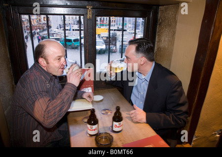 Les touristes toast une bière belge dans Le Roy d'Espagne bar. Grand Place, Bruxelles. Belgique Banque D'Images