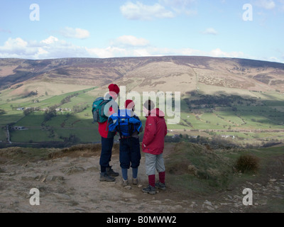 Trois marcheurs regarder vers le nord depuis le sommet de Mam Tor sur la vallée de Edale. Parc national de Peak District. Le Derbyshire. UK. Banque D'Images