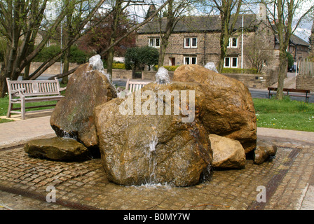 Une fontaine d'eau dans un morceau de sculpture moderne dans un parc de la rue principale de Burley Wharfedale Banque D'Images