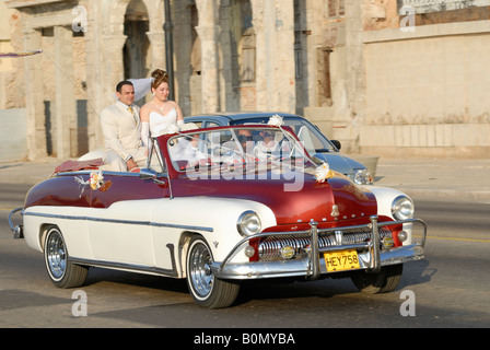 Une suite nuptiale couple roulant en voiture américaine vintage road sur le Malecon à La Havane Cuba Avril 2007 Banque D'Images