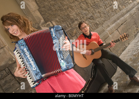 Nouveau jeune groupe folklorique gallois CALAN arts de la rue dans le Nord du Pays de Galles - Caernarfon Gwynedd girl playing accordion, garçon à la guitare Banque D'Images