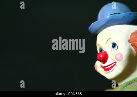 Un jouet le visage de clown sur un fond sombre Banque D'Images