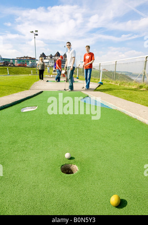 Deux hommes jouant à mi 20s mini-golf à Whitby, North Yorkshire, UK Banque D'Images