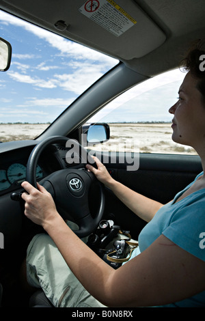 Femme au volant d'une voiture dans le Parc National d'Etosha, Namibie Banque D'Images