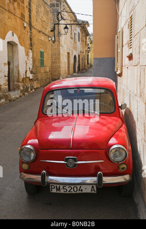 Une voiture contre un mur dans une rue étroite de la vieille ville à Alcudia, Majorque, Espagne. Banque D'Images