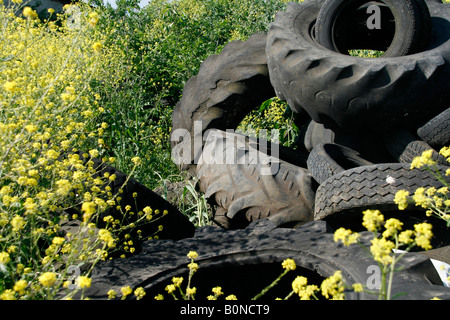 Vieux pneus du tracteur dans le champ gauche en campagne Banque D'Images