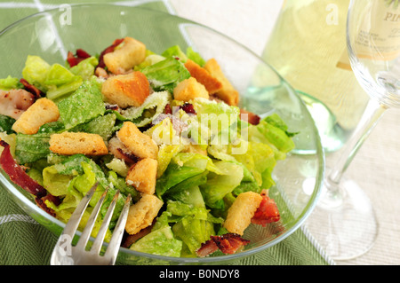 Salade César, servi dans un bol en verre et le vin blanc Banque D'Images