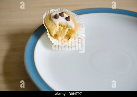 À moitié mangé cupcake disposées sur une plaque bleu et blanc de Chine Banque D'Images