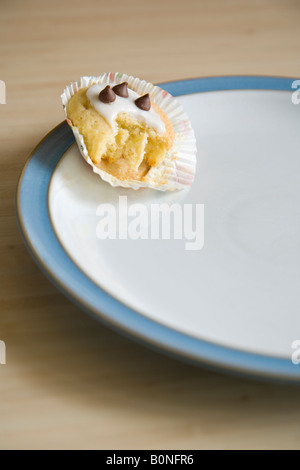 À moitié mangé cupcake disposées sur une plaque bleu et blanc de Chine Banque D'Images