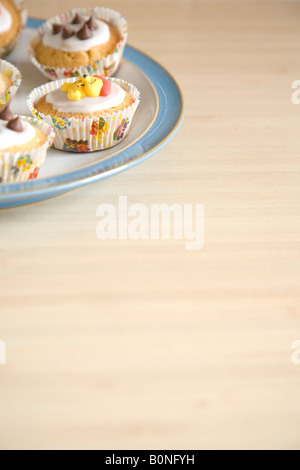 Cupcakes colorés disposés sur une plaque bleu et blanc de Chine Banque D'Images