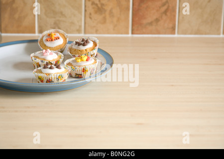 Cupcakes colorés disposés sur une plaque bleu et blanc de Chine Banque D'Images