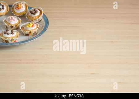 Cupcakes colorés disposés sur une plaque bleu et blanc de Chine Banque D'Images