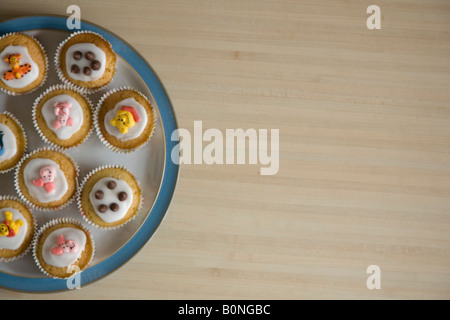 Cupcakes colorés disposés sur une plaque bleu et blanc de Chine vue d'en haut Banque D'Images