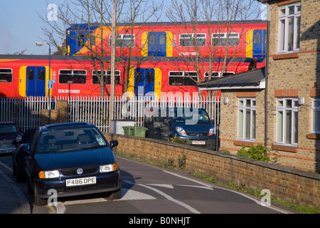 Deux passage des trains passant dans une zone résidentielle, sur des pistes différentes, et à proximité de voitures en stationnement. Twickenham, l'ouest de Londres. UK. Banque D'Images