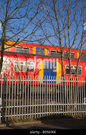 Deux passage des trains passant sur des pistes différentes, et une voiture en stationnement. Twickenham, l'ouest de Londres. UK. Banque D'Images