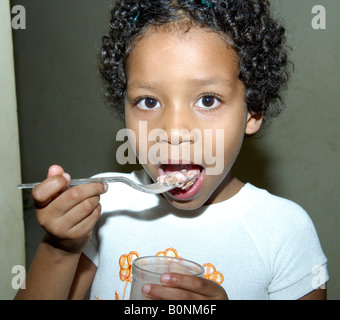 Une jeune brunette Brazilian girls eating ice-cream avec une cuillère Banque D'Images