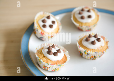 Cupcakes colorés disposés sur une plaque bleu et blanc de Chine Banque D'Images