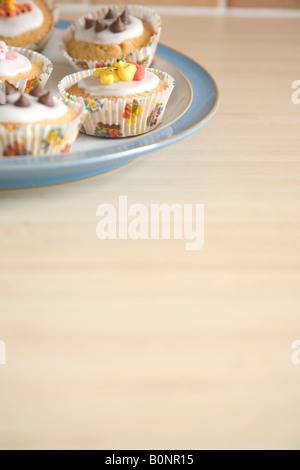 Cupcakes colorés disposés sur une plaque bleu et blanc de Chine Banque D'Images