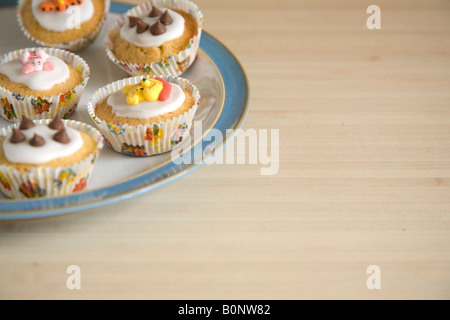 Cupcakes colorés disposés sur une plaque bleu et blanc de Chine Banque D'Images