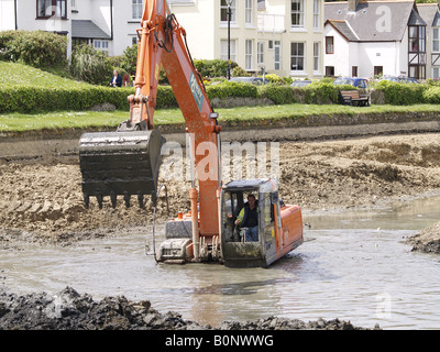 Digger travailler profondément dans la boue et l'eau d'enlever le bas de canal de Bude, Cornwall, UK Banque D'Images