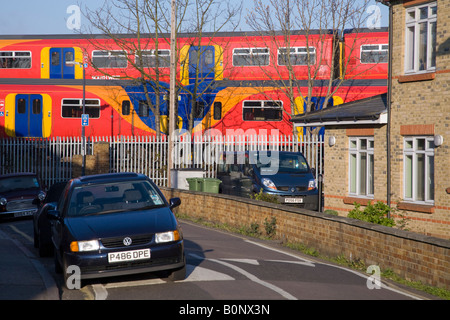 Deux passage des trains passant dans une zone résidentielle, sur des pistes différentes, et à proximité de voitures en stationnement. Twickenham, l'ouest de Londres. UK. Banque D'Images