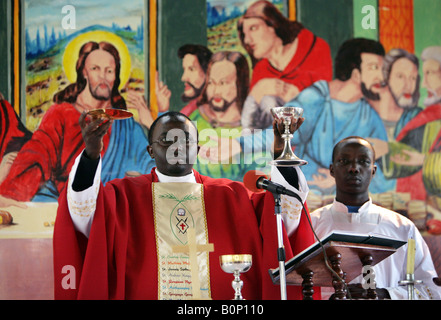 Prêtre catholique holding wine et du pain au cours de l'Eucharistie dans une église de Kikuyu, Kenia Banque D'Images