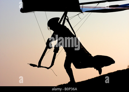 Silhouette de pilote de deltaplane décollant Banque D'Images