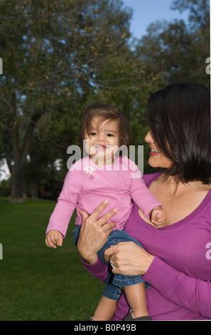 Portrait de Mère Navajo vertical et un an fille smiling outdoors dans un parc Banque D'Images