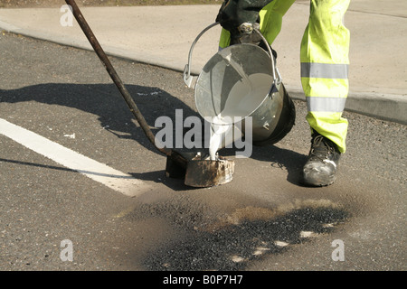 Marquage routier, piste de route, garder à l'écart, Santé et sécurité, peinture de route, Hommes au travail, peinture pour chariot, marqueur de ligne, suivant la ligne de trottoir, repère jaune. Banque D'Images