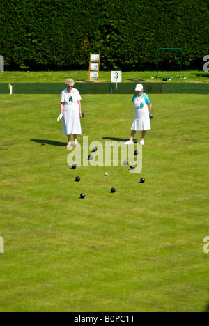 View vertical de deux dames, le patron et le numéro 3, à la 'head' au cours d'un jeu de boules au soleil. Banque D'Images