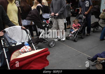 Parent et leurs enfants en poussette impasse formulaire sur la Cinquième Avenue à New York Banque D'Images