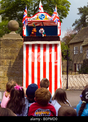 Les enfants regardant un Punch and Judy Show traditionnel dans un village anglais Banque D'Images