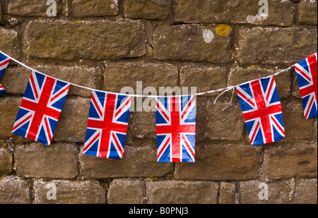 Vue rapprochée de l'Union Jack drapeaux guirlandes avec un mur de pierre derrière Banque D'Images