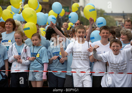 Foule d'enfants avec des ballons concurrents alignés sur la ligne de départ du marathon fun run 2008 Belfast Belfast City Centre n Banque D'Images